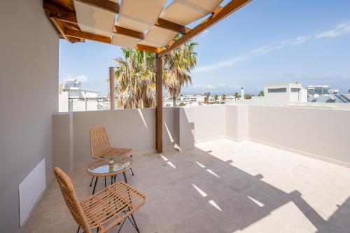 a patio with two chairs and a table on a roof at Aeolos Loft - 3 min Walk to Beach & Town in Kos