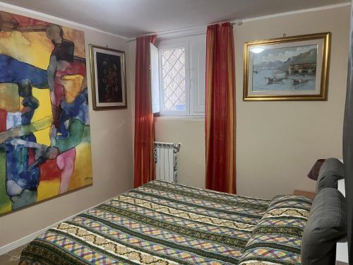 a bedroom with a bed and a painting on the wall at Casa SoleMare a pochi passi dalla spiaggia di Terracina in Terracina