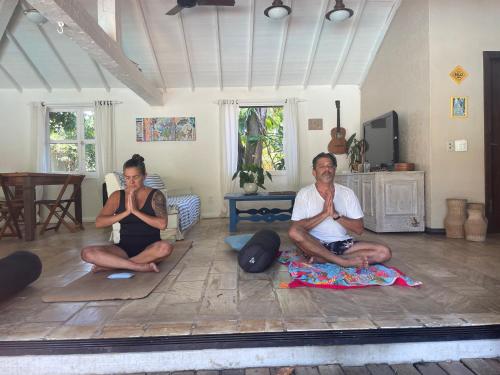 two people sitting on the floor in a room at Morada do Sol Guest House in Búzios
