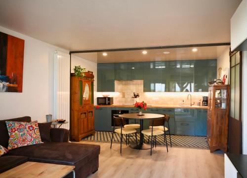 un salon avec un canapé et une table et une cuisine dans l'établissement Appart-terrasse , 80m de la plage Benoît, La BAULE, à La Baule