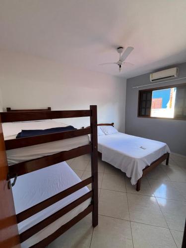 a bedroom with two bunk beds and a window at Apto bem equipado, com 2 quartos acomoda até 6 pessoas confortavelmente in Ubatuba