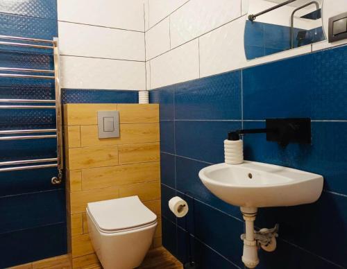 a blue and white bathroom with a toilet and a sink at Sielski Zakątek in Srokowo