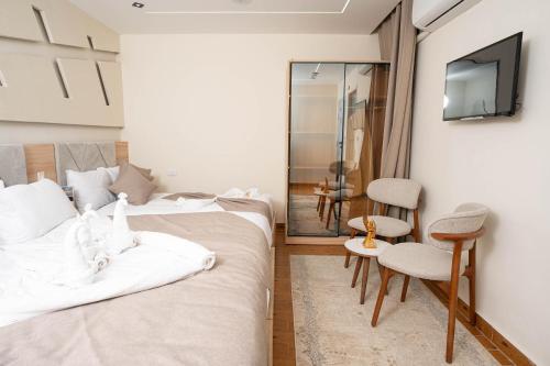 two beds in a room with a tv and a chair at Camel Pyramids View Inn in Cairo