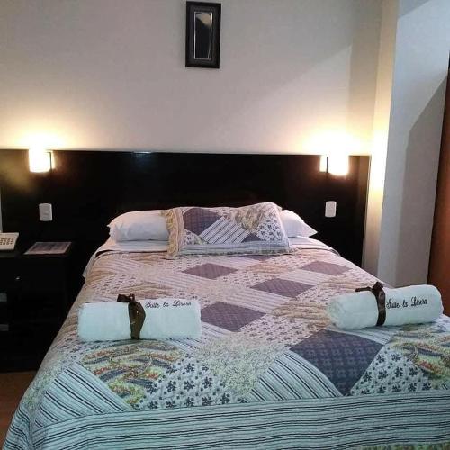 a large bed with two pillows on top of it at La Lisera Suite Residencial in Tacna