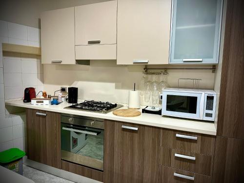 a kitchen with a microwave and a stove at San Paolo Short Rental in Campobasso