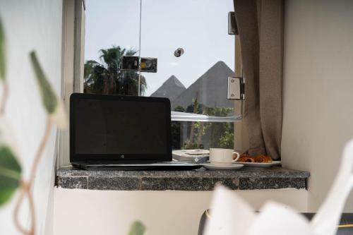 a laptop computer sitting on a counter in a window at Camel Pyramids View Inn in Cairo