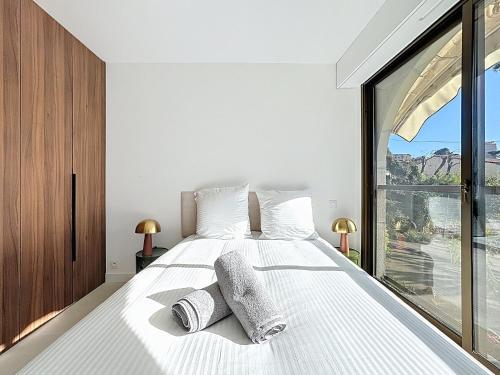 une chambre avec un grand lit blanc avec deux oreillers dans l'établissement 2 pièces vue mer, piscine, à 2 pas des plages, à Cannes
