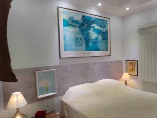a bedroom with a bed and a picture on the wall at Casa com vista exuberante in Pouso Alegre