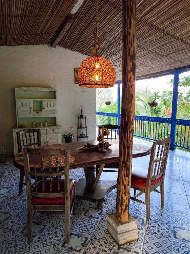 a dining room with a wooden table and chairs at Finca Rústica, Cocorná - Cacao, Charcos y Cascadas in Cocorná