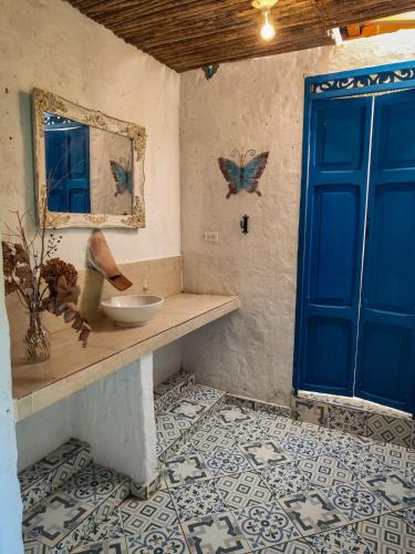 a bathroom with a sink and a blue door at Finca Rústica, Cocorná - Cacao, Charcos y Cascadas in Cocorná