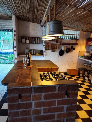 a kitchen with a stove and a brick wall at Finca Rústica, Cocorná - Cacao, Charcos y Cascadas in Cocorná