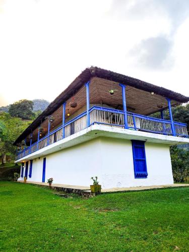 a building with a balcony on the side of it at Finca Rústica, Cocorná - Cacao, Charcos y Cascadas in Cocorná