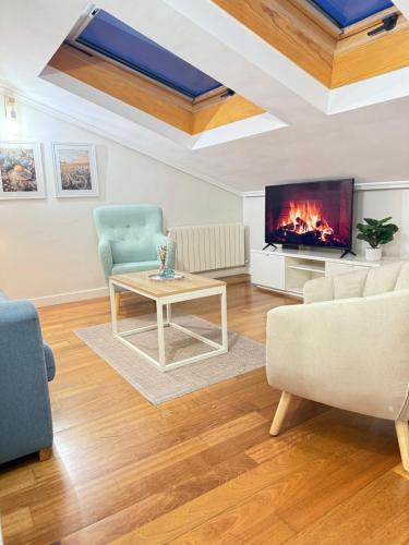 a living room with a couch and a table and a fireplace at Mirador del cielo in Avila