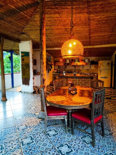 a dining room with a wooden table and chairs at Finca Rústica, Cocorná - Cacao, Charcos y Cascadas in Cocorná