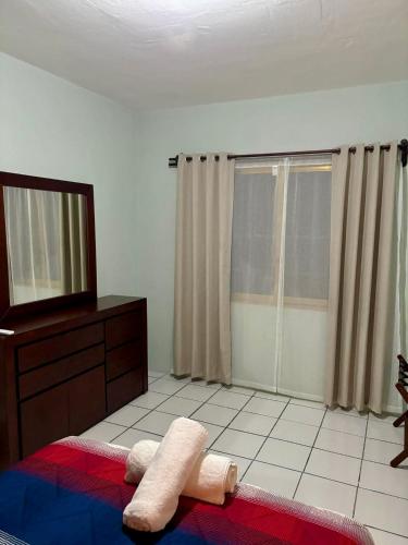 a bedroom with a bed and a dresser and a window at Casa María Bonita in Boca del Río