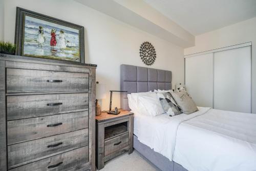 a bedroom with a large bed and a dresser at CHOL Furnished Suites Heart of Downtown Toronto, 2 Beds, Free Parking, CN Tower View in Toronto