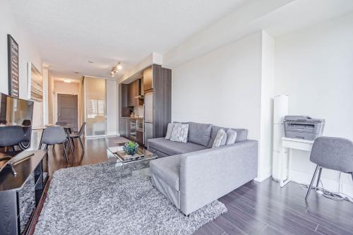 a living room with a couch and a table at CHOL Furnished Suites Heart of Downtown Toronto, 2 Beds, Free Parking, CN Tower View in Toronto