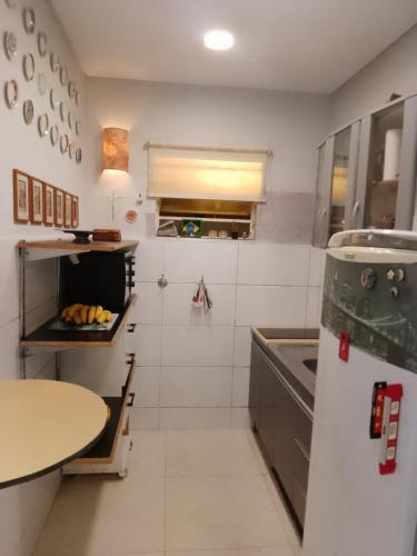 a kitchen with a refrigerator and a table in it at Casa com vista exuberante in Pouso Alegre