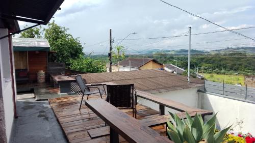 a wooden deck with chairs and a table on a house at Casa com vista exuberante in Pouso Alegre