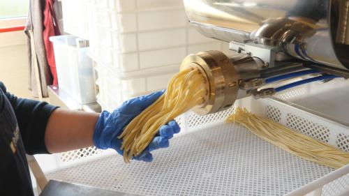 a person using a machine with a bunch of spaghetti at Il Poggio degli Antichi Sapori - Residence in Paternopoli