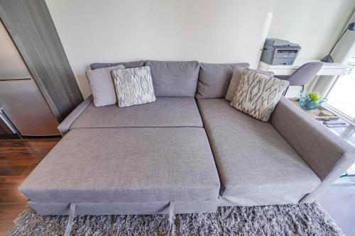 a couch with two pillows on it in a living room at CHOL Furnished Suites Heart of Downtown Toronto, 2 Beds, Free Parking, CN Tower View in Toronto