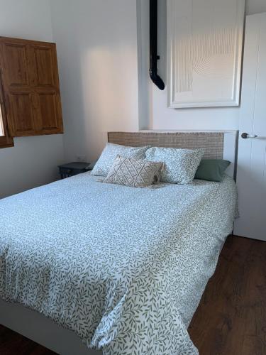 a bed with a blue comforter and pillows on it at Melgar's Place, Bajo con terraza in Santo Domingo de la Calzada