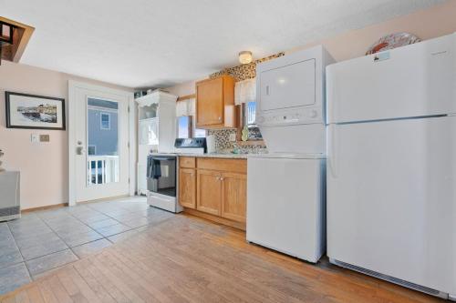 a kitchen with white appliances and wooden cabinets at Sweet Maine Cottage in Camp Ellis in Saco