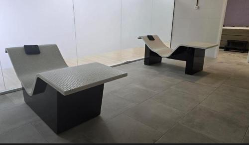 two chairs and a bench in a room at Apartamento Blois Deluxe Comfort in Rivas-Vaciamadrid