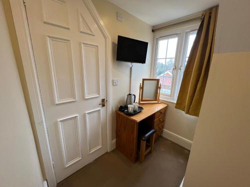 a room with a door and a desk with a mirror at The Shoe Inn Rooms in Southampton