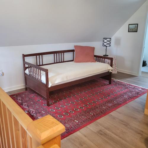 a bed sitting on top of a red rug in a room at Old Library Lodge in Killaloe Station