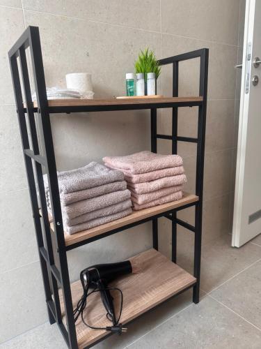 a bathroom shelf with towels and a hair dryer at Apartman MINI MI 2 in Zagreb