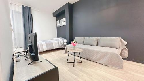 un salon avec un canapé et une télévision dans l'établissement Modern and comfortable apartment, à Villepinte