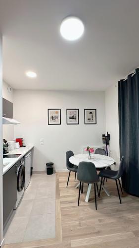 une cuisine et une salle à manger avec une table et des chaises dans l'établissement Modern and comfortable apartment, à Villepinte