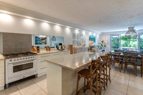a kitchen and dining room with a table and chairs at Poinciana 012 & Free Buggy Hamilton Island in Hamilton Island