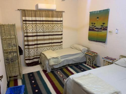 a small room with two beds and a window at Shahd Siwa in Siwa