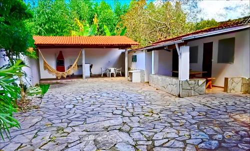 a house with a stone patio in front of it at Cantinho de Pirenópolis in Pirenópolis