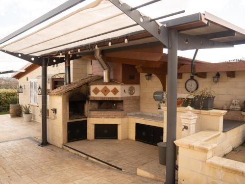 an outdoor kitchen with an outdoor oven in a patio at Il Poggio degli Antichi Sapori - Residence in Paternopoli