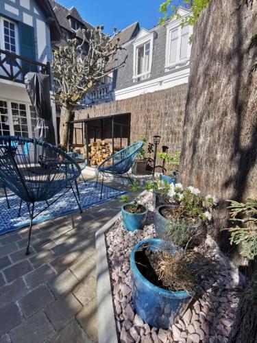 d'une terrasse avec trois pots bleus et des plantes. dans l'établissement Villa normande - Les Crapauds Fous - proximité Centre Ville et Plage, à Deauville