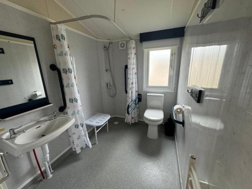 une salle de bain avec des toilettes blanches et un lavabo dans l'établissement Fantasy Island Resort - The Pearl, with Hot Tub - Coastal Caravan Breaks, à Ingoldmells