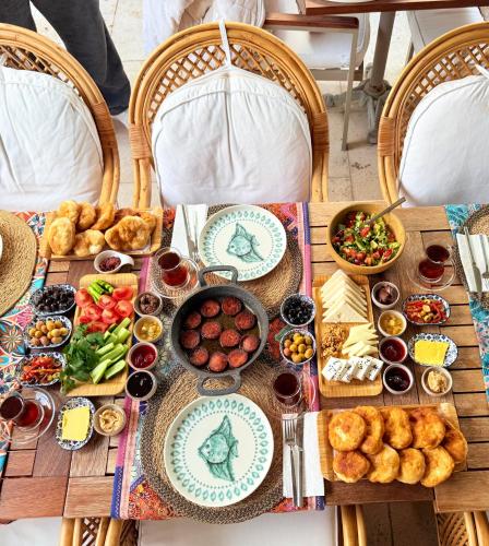 a table with food and plates of food on it at Kotraba Alacati Hotel in Alacati