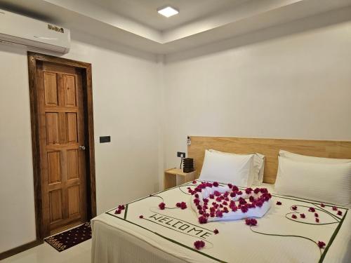 a bedroom with a bed with flowers on it at Sunset Beach View in Dhangethi