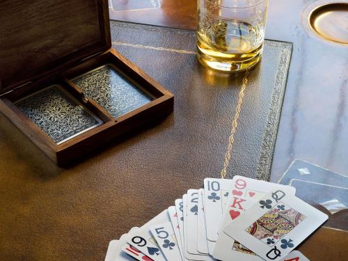 a table with a playing cards and a glass of whiskey at Boutique Hotel La Madrugada in Benissa