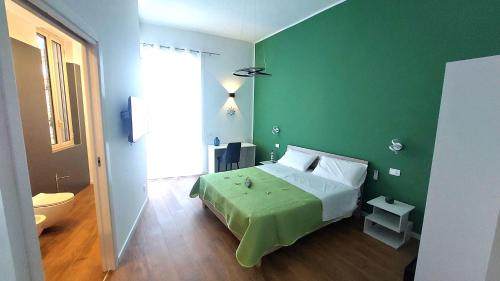 a green bedroom with a bed and a toilet at La Terrazza Del Sole di Mondello in Palermo