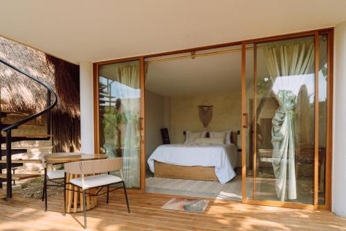 a bedroom with a bed and sliding glass doors at VelaNova Paradise - HotelRetreat in Isla Fuerte