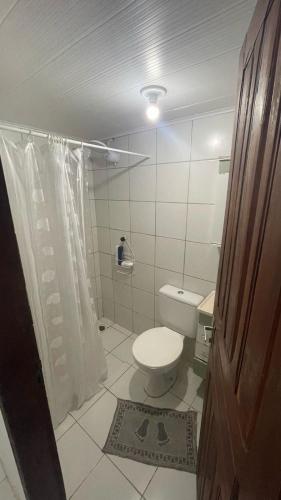a small bathroom with a toilet and a shower at Casa do Arnaldinho in São Miguel dos Milagres