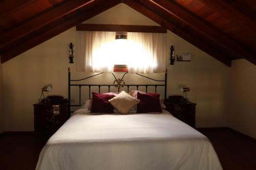 a bedroom with a large bed with red pillows at Casa Las Sabinas in Guarazoca