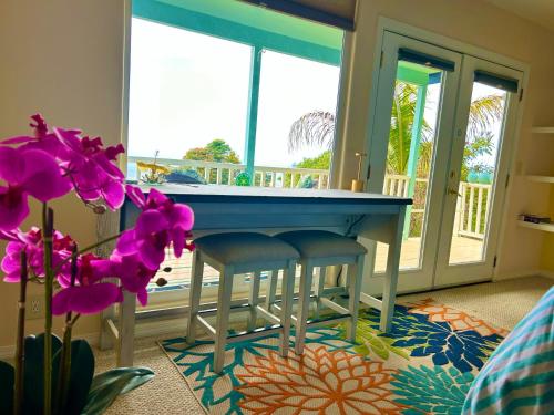 a kitchen with a blue table and two stools at Kailua Kona Overlook Suites in Kailua-Kona