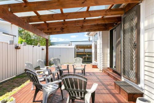 a patio with chairs and a table on a deck at Central Family Home 5 min to CBD! in Gisborne