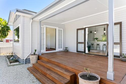 a house with a wooden porch with a deck at Central Family Home 5 min to CBD! in Gisborne