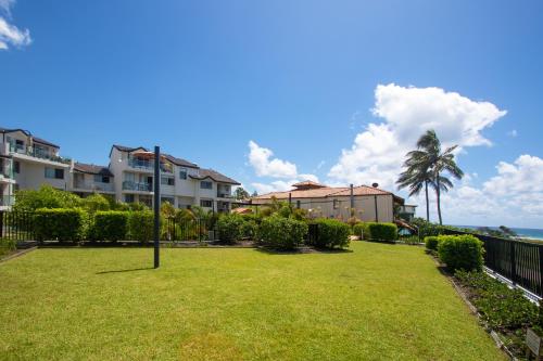 a park with a lawn and some buildings and the ocean at Sandcastles On Currumbin Beachfront, Gold Coast in Gold Coast